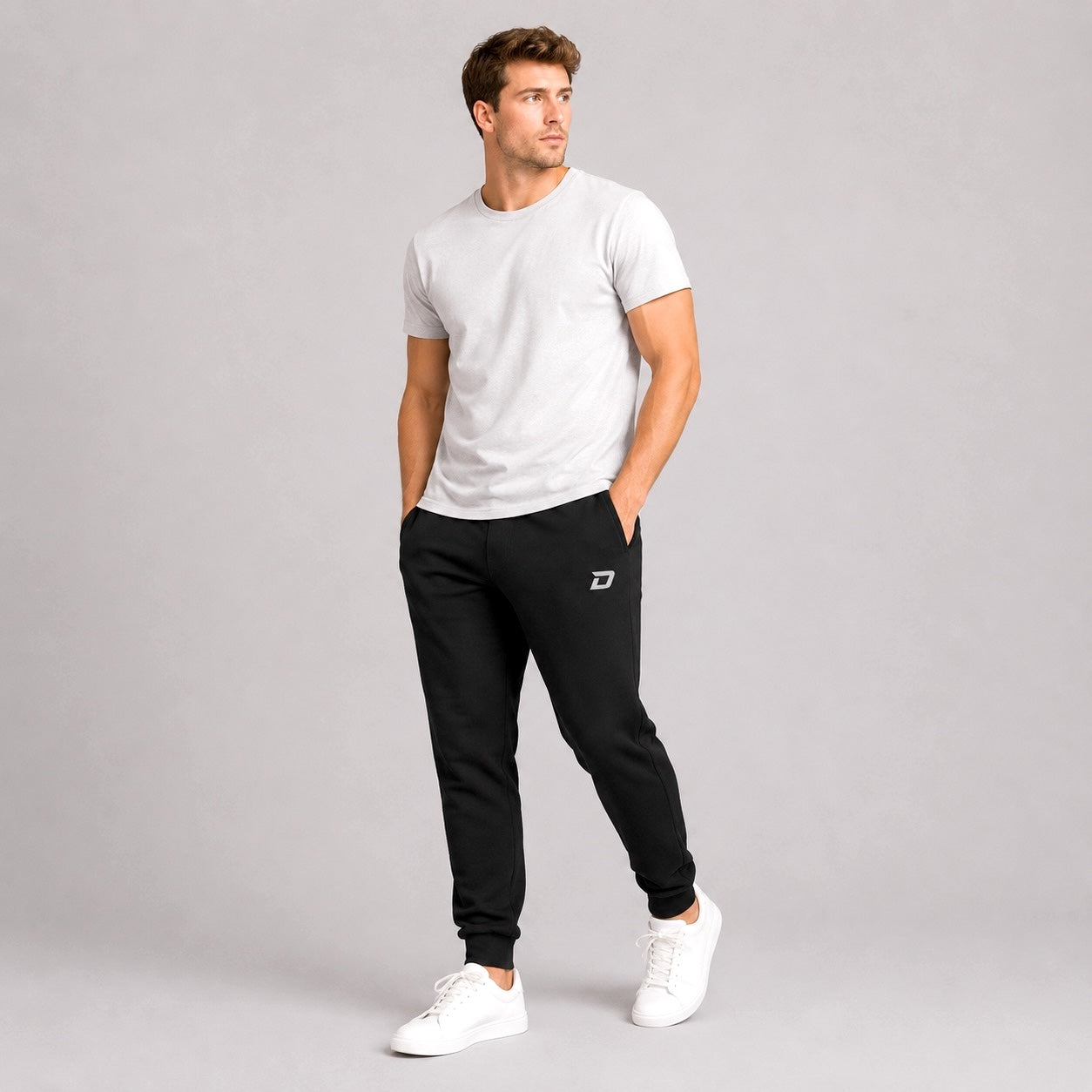 Male model wearing the Dink Air black Classic Joggers with a white tee in a casual lifestyle setting.