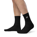Black performance crew socks featuring the embroidered D Mark logo, designed for pickleball and everyday athletic wear.