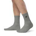 Heather gray premium embroidered crew socks featuring the signature D Mark logo, worn with athletic apparel for pickleball and everyday comfort.