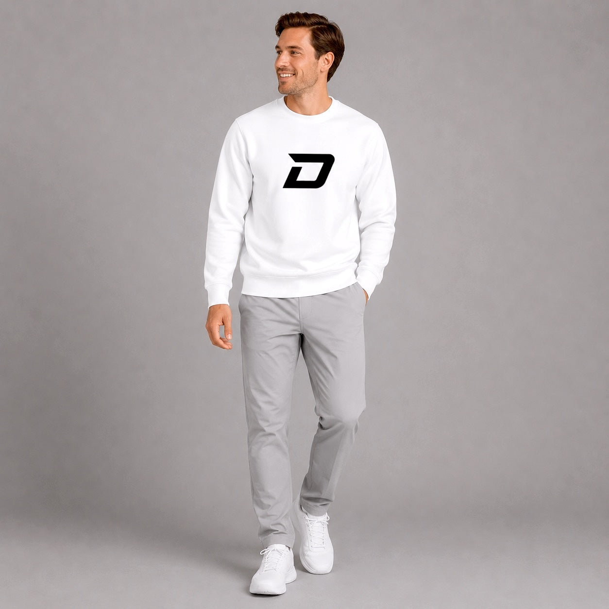 Lifestyle image of a model wearing the white D Mark Sweatshirt with matching athletic apparel.