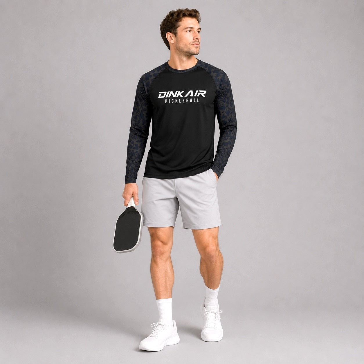 Male model wearing the Midnight Performance Long Sleeve Tee and white performance shorts in an athletic lifestyle setting.