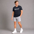 Male model wearing the Midnight Performance Tee and white performance shorts in an athletic lifestyle setting.