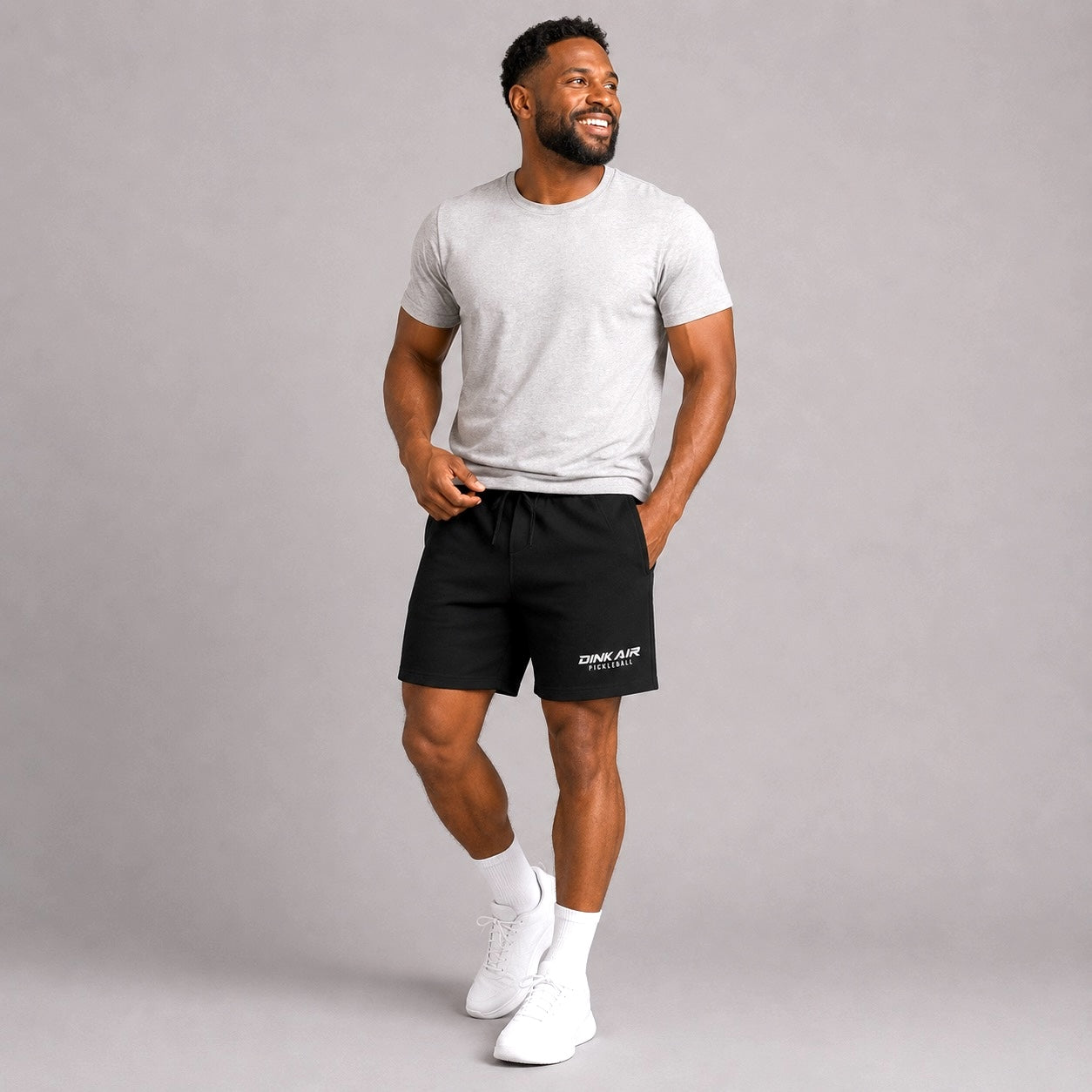 Male model wearing the black Signature Pickleball Fleece Shorts and a white Dink Air tee in a casual lifestyle setting.