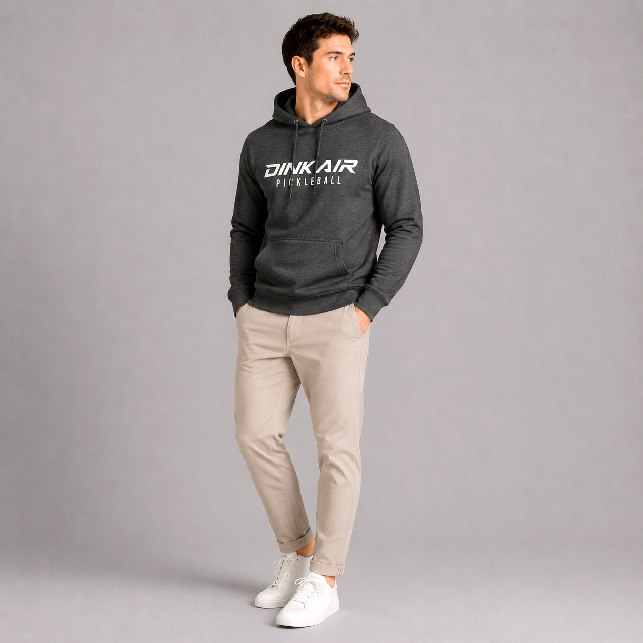 Male model wearing the gray Signature Pickleball Hoodie featuring the Dink Air Pickleball logo, styled with light pants in a clean studio setting that highlights the hoodie’s casual comfort and everyday versatility on and off the court.