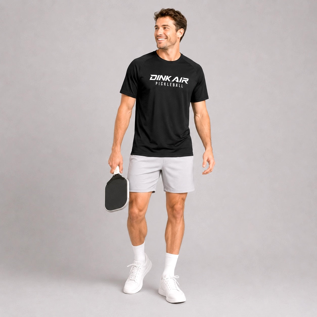 Male model wearing the black Signature Pickleball Performance Tee and white performance shorts in an athletic lifestyle setting.