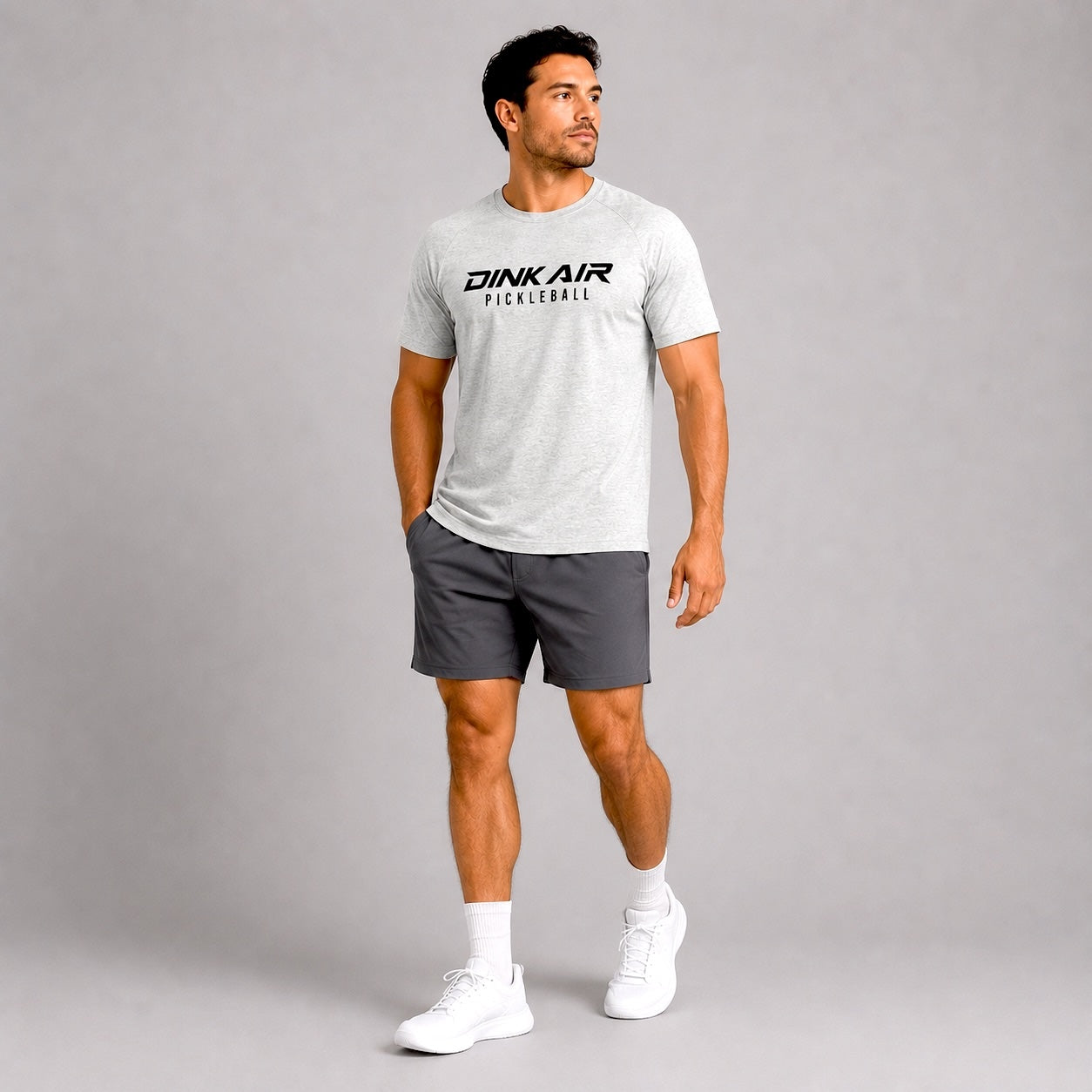 Lifestyle image of a model wearing the gray Signature Pickleball Tee in a casual athletic setting.