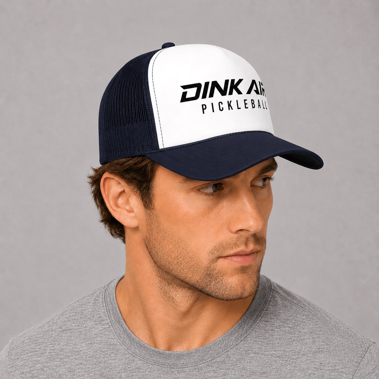Lifestyle image of a male model wearing the Signature Pickleball Trucker Hat with a casual athletic outfit.